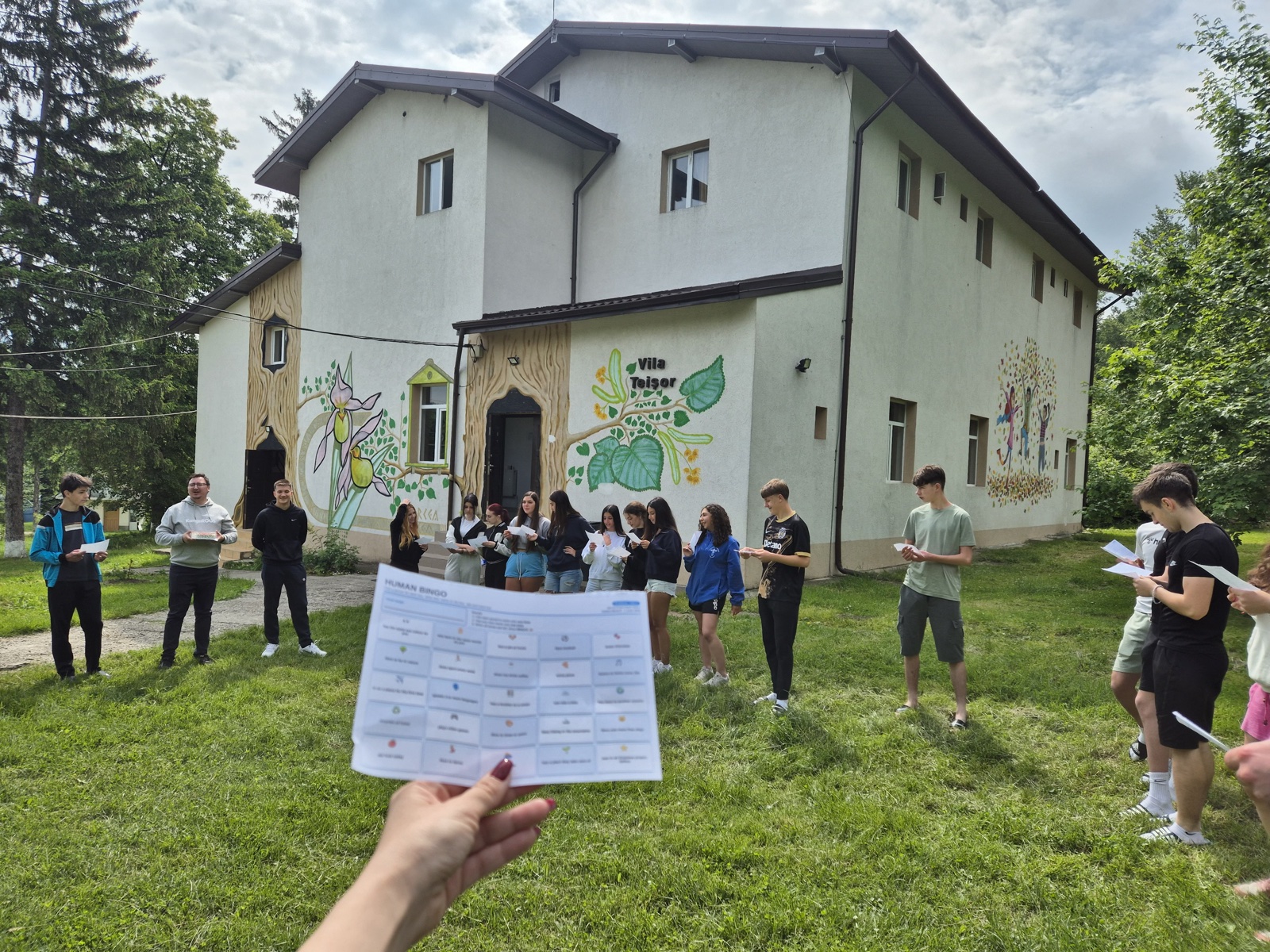 A participant holds up the Human Bingo sheet in front of the group