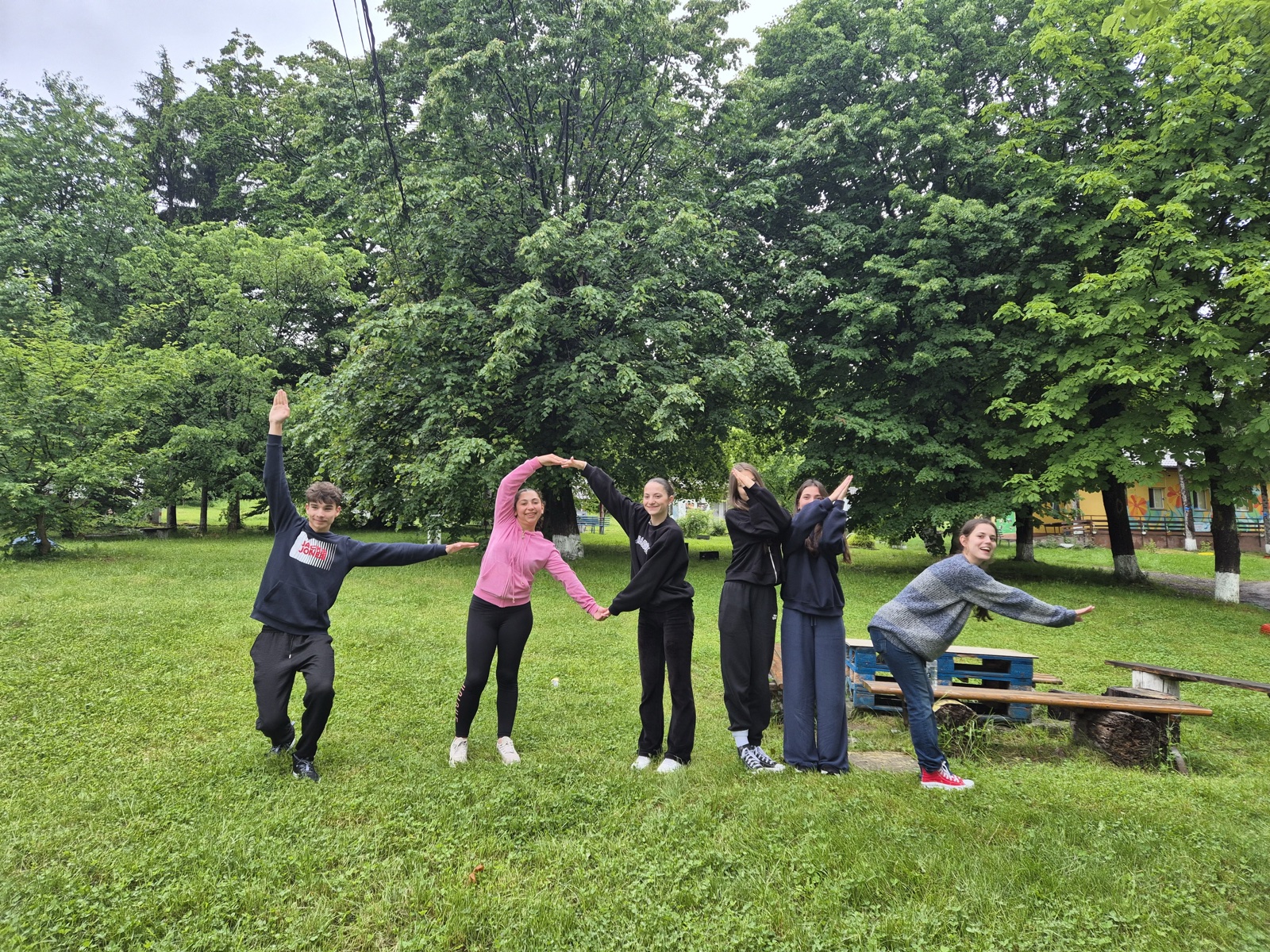 A team spells out letters with their bodies on the camp lawn