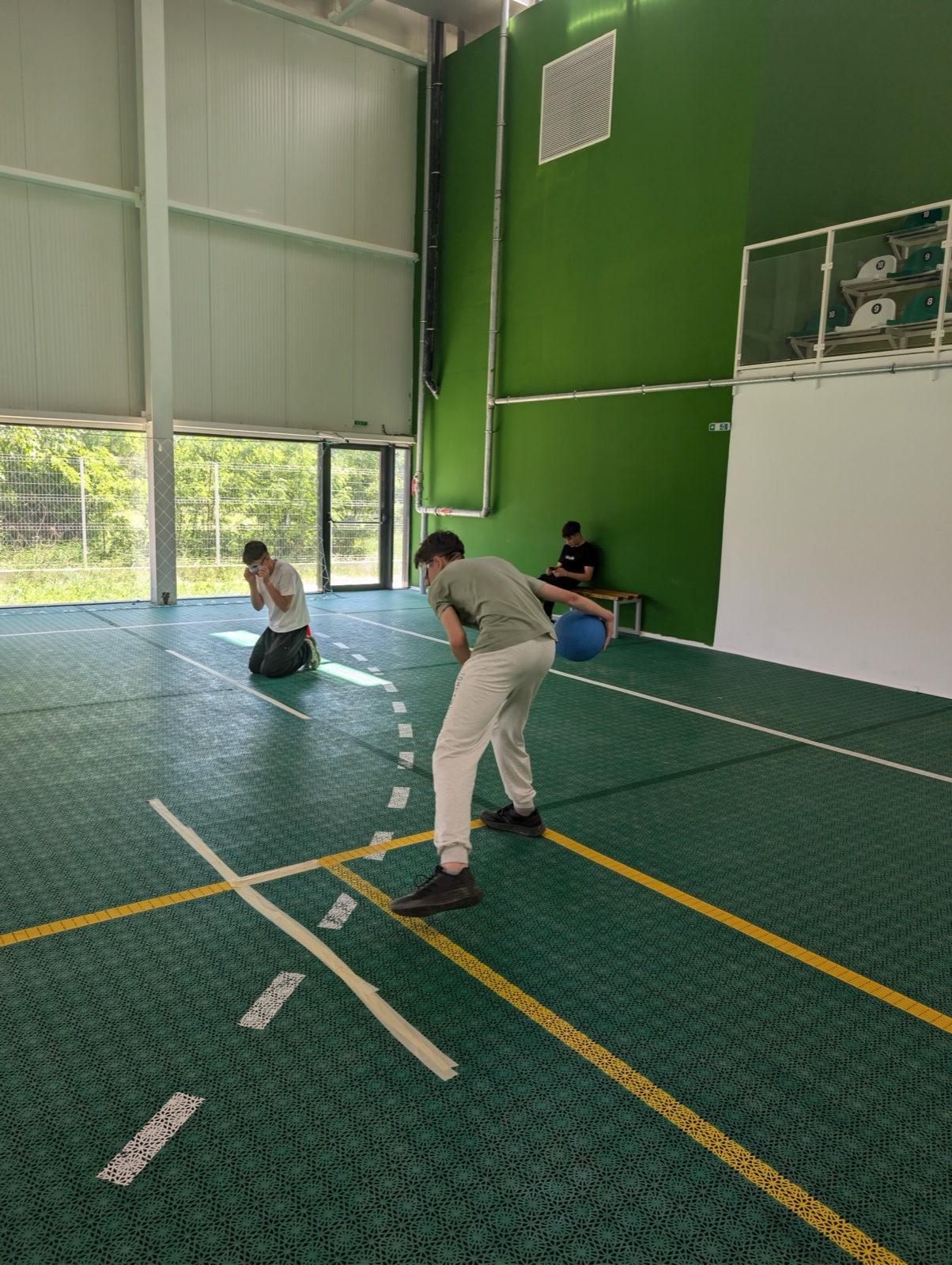 A blindfolded player holds the goalball, listening for his teammates before the throw