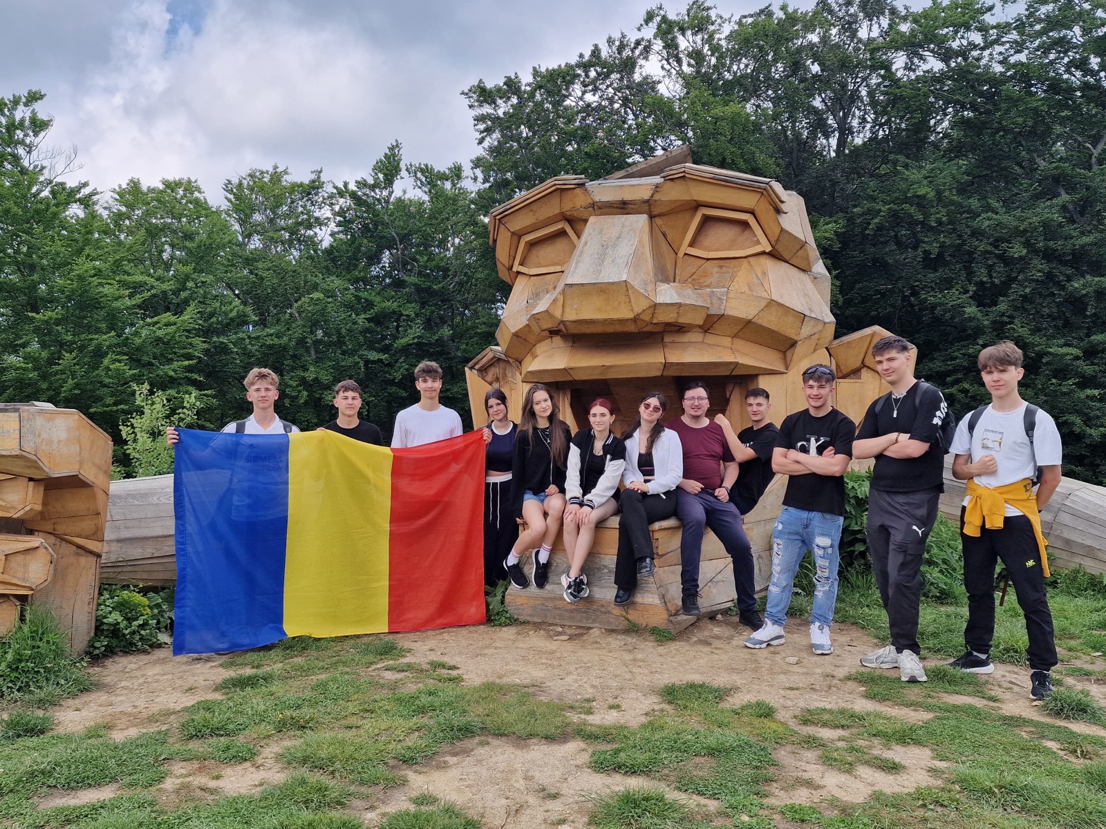 The Romanian team with their flag at the troll sculpture
