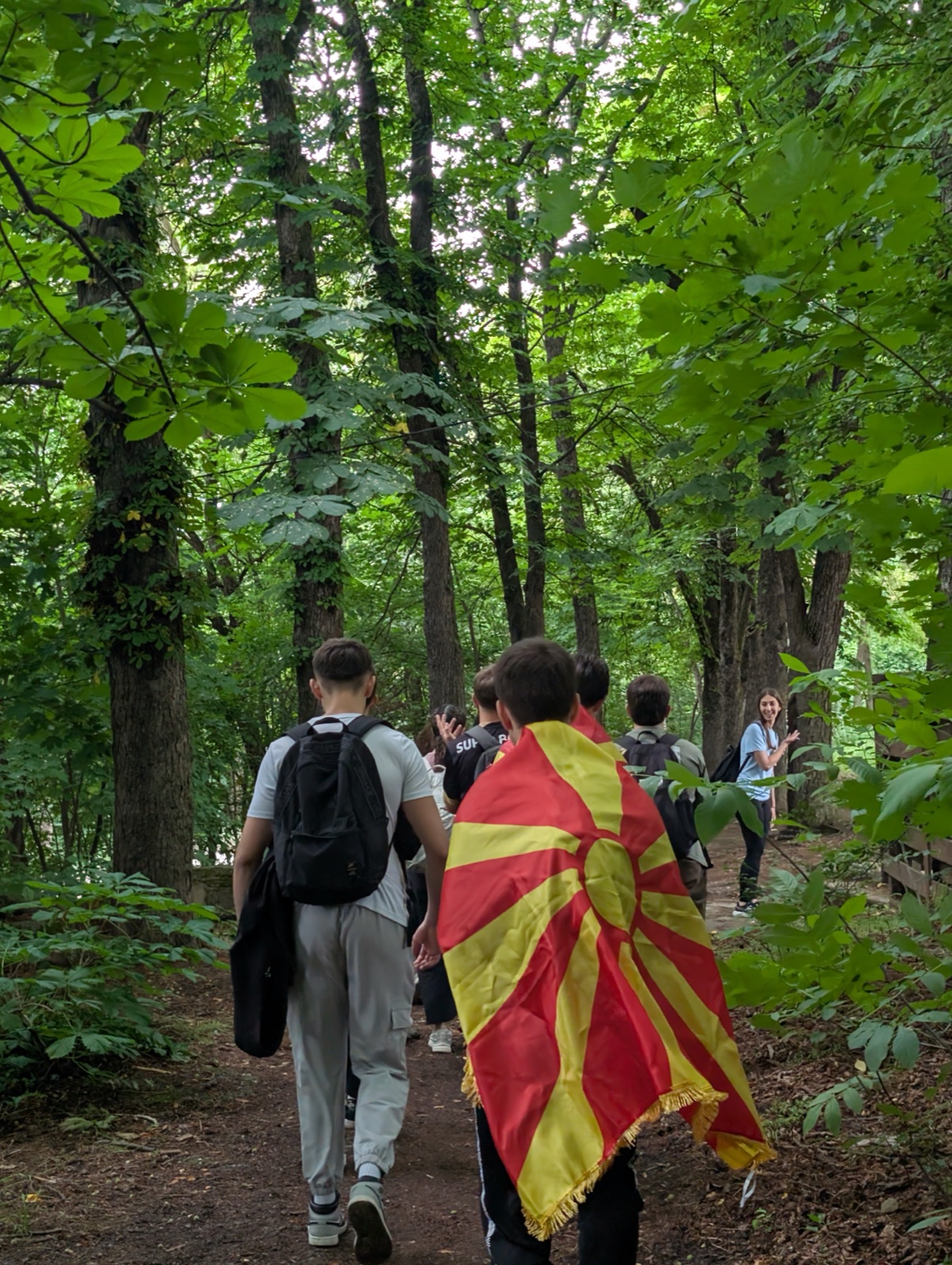 A hiker wears the North Macedonian flag on the forest trail