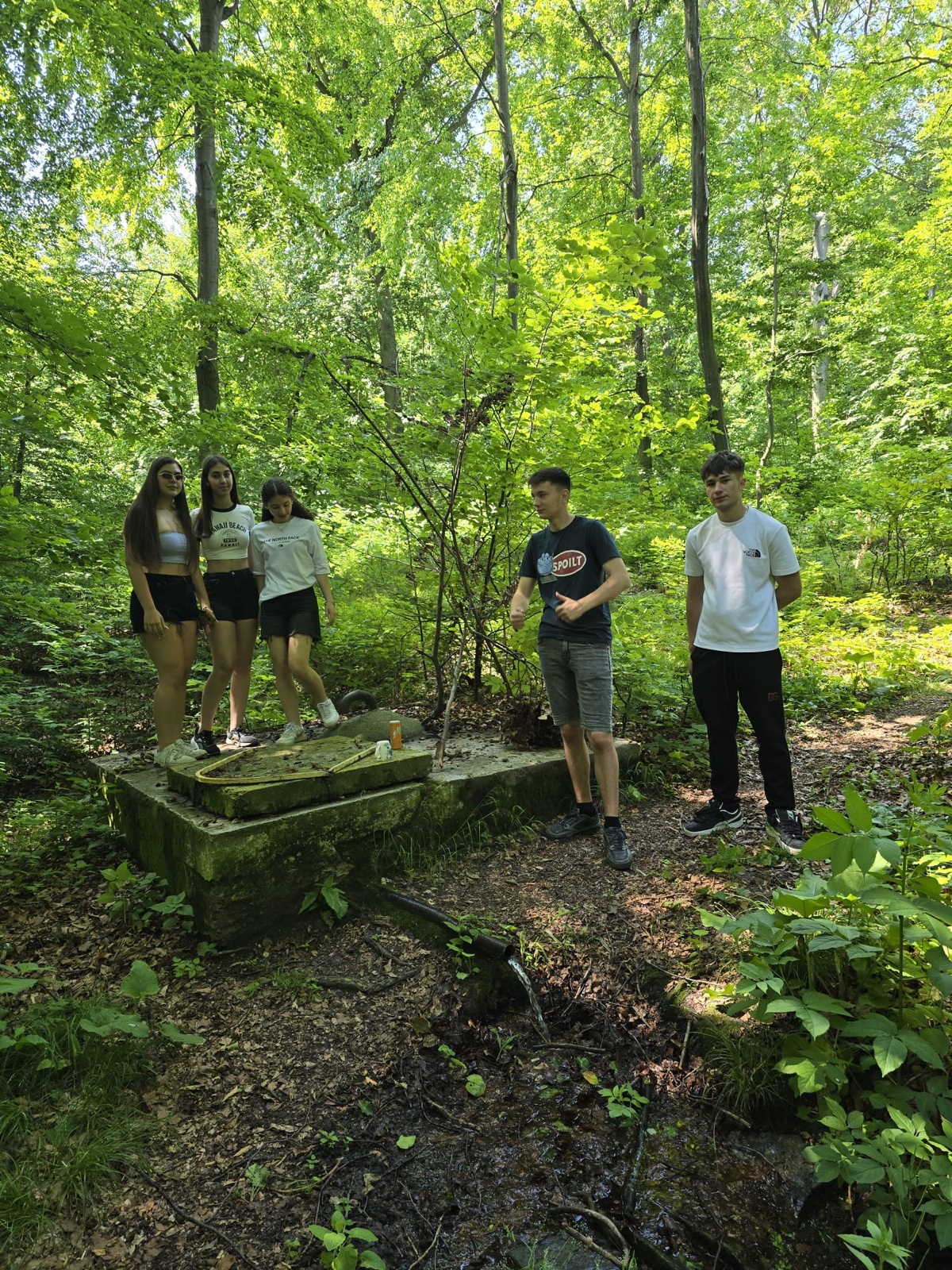 A treasure-hunt team crouches for a photo deep in the forest
