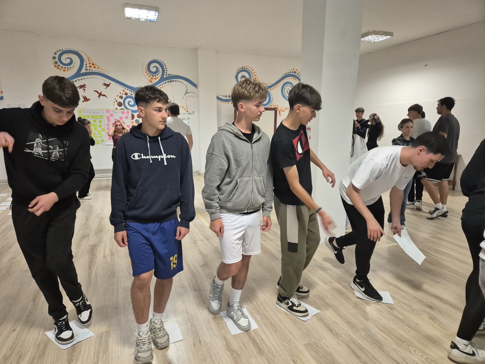 A blindfolded participant feels her way through a tape maze at a Racetracks station